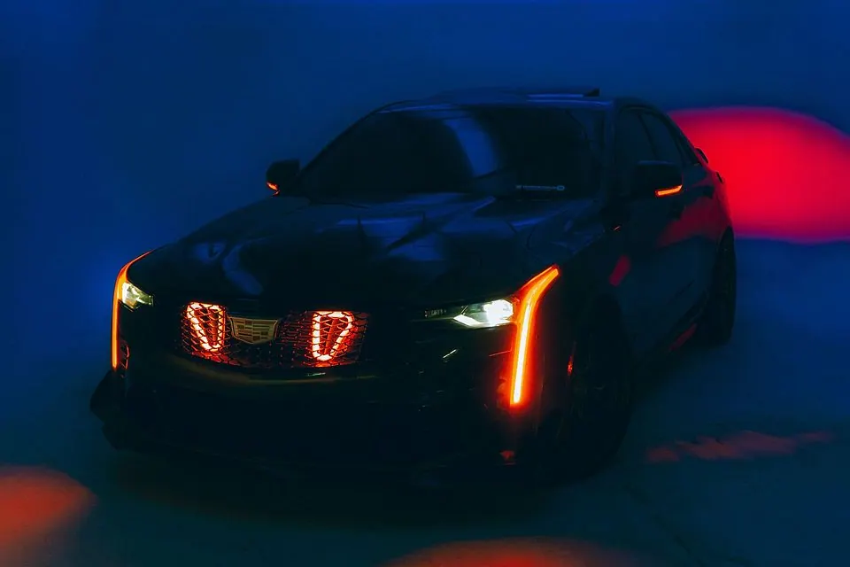Чёрный Cadillac CT5-V в студии с синим светодиодным потолком и красным светом