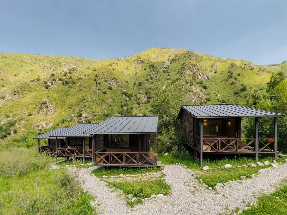 Ряд модульных домиков Cabin на зелёном склоне