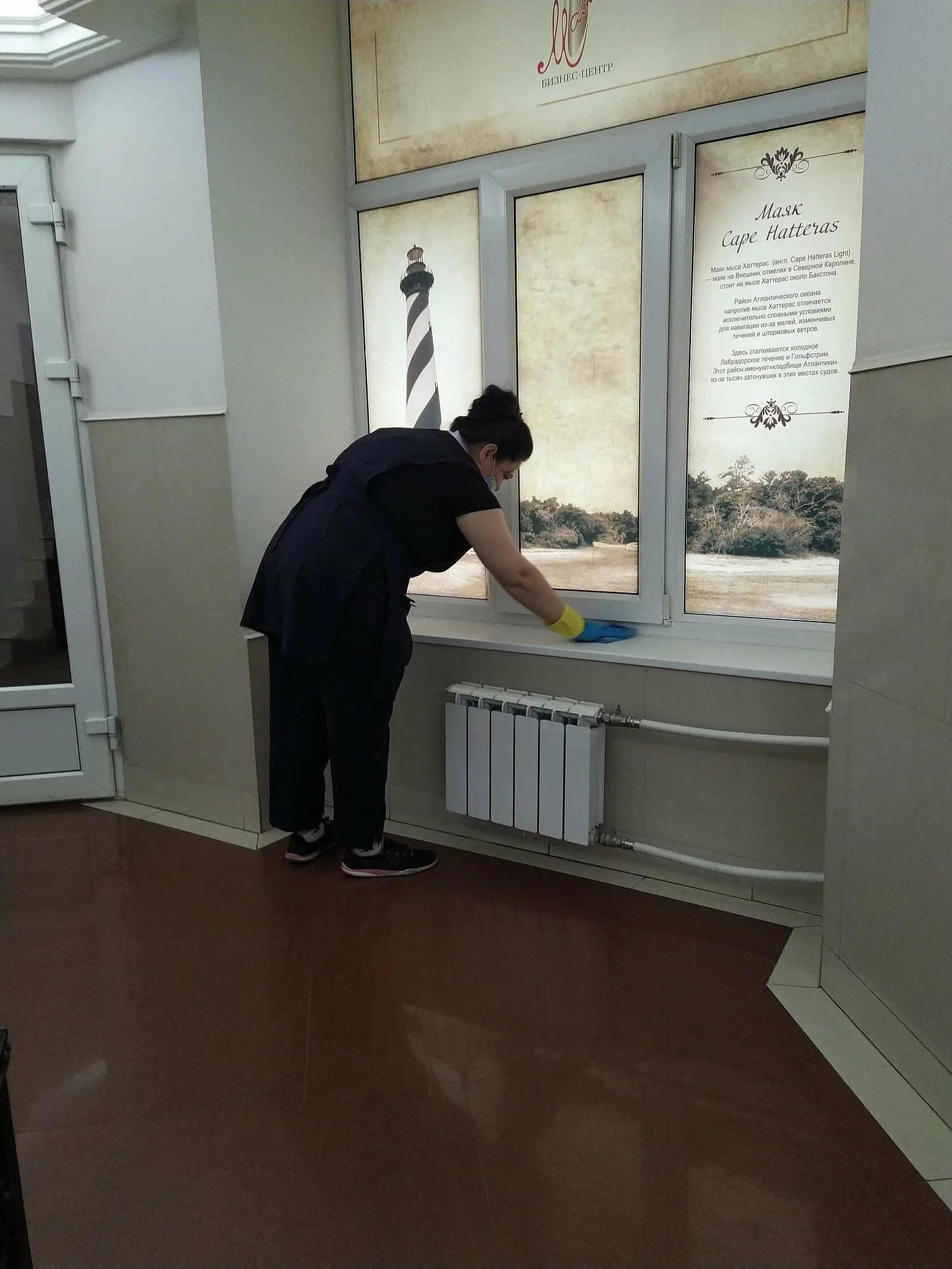 Сотрудница протирает подоконник в холле